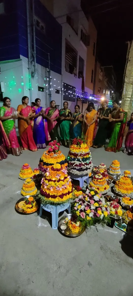Women gather around their bathukammas, towers of flowers, in Telangana.