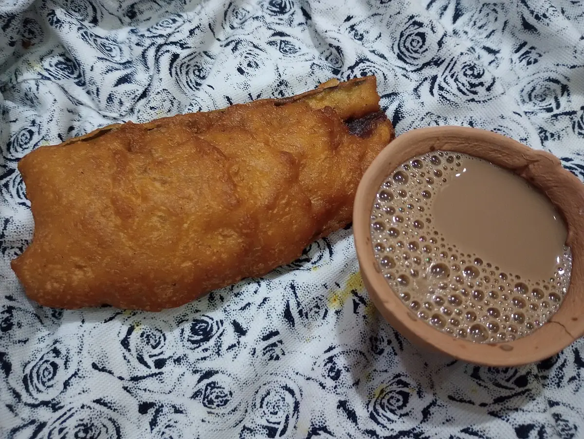 Beguni, brinjal in a crisp gram-flour batter, with a cup of tea.
