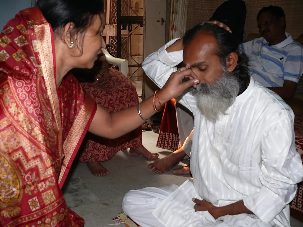 A sister puts the phonta on her brother's forehead for Bhai Phonta.