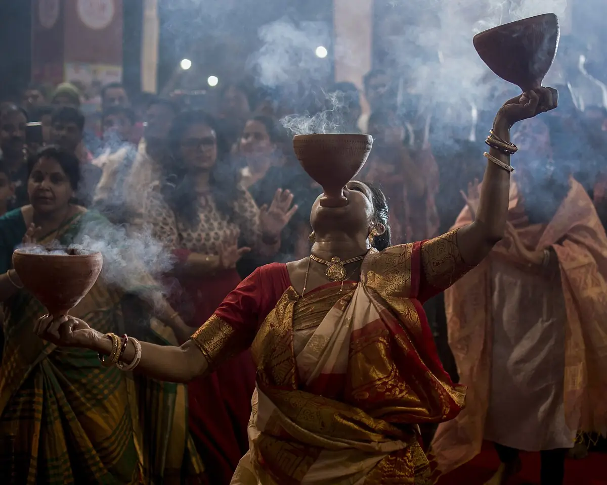 Dhunuchi dance: clay burners of smoking coconut husk and incense, held aloft to the dhak.