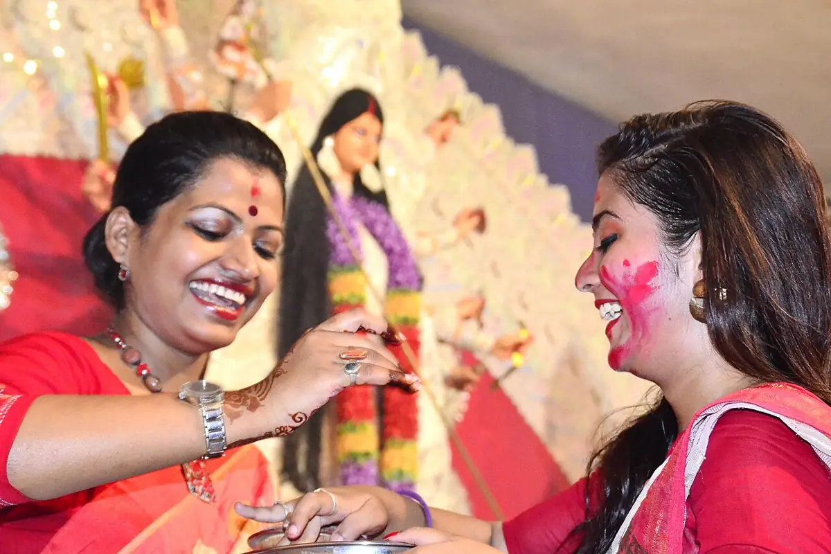 Women smear sindoor on each other on Bijoya Dashami.